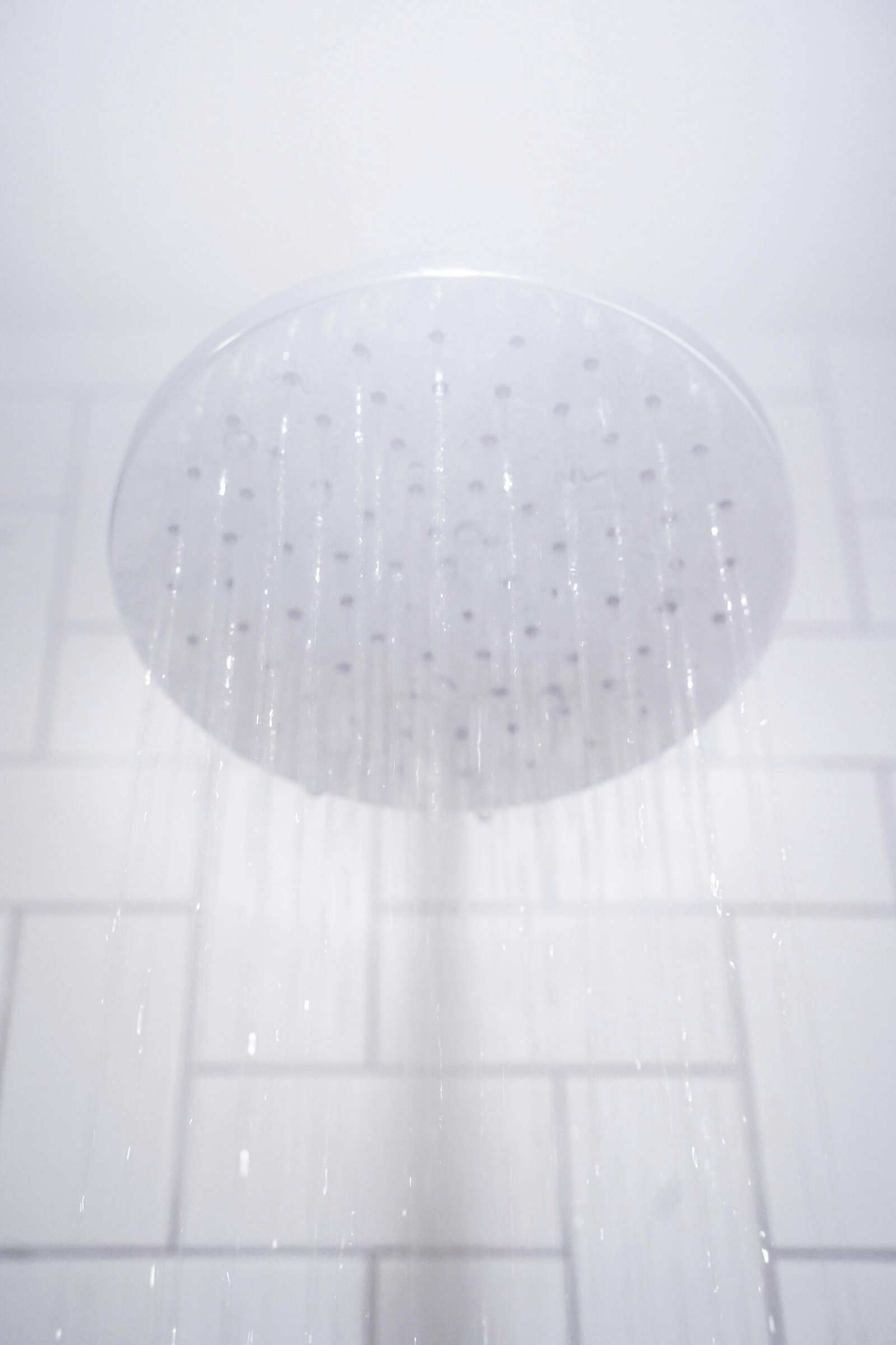 water from round gray stainless steel shower head